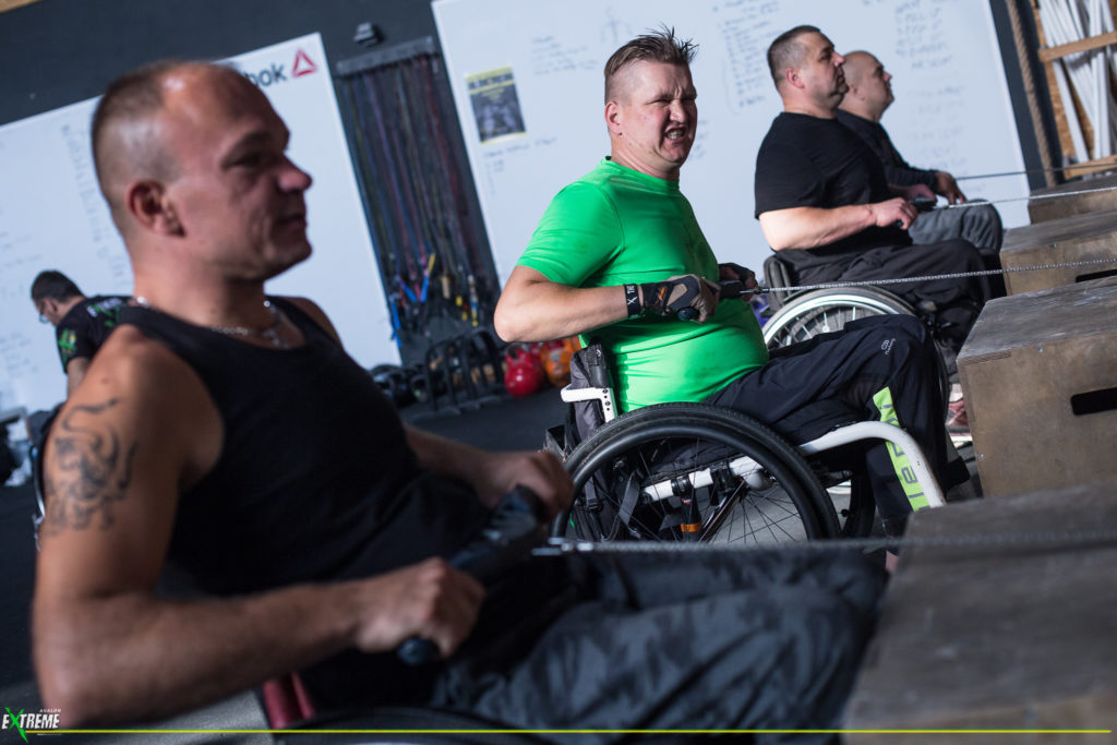 Zdjęcia przedstawia czterech mężczyzn na wózkach w trakcie treningu siłowego.
