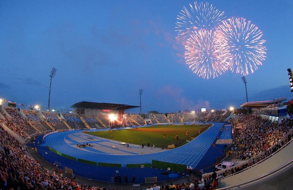 Zdjęcie przedstawia duży stadion i fajerwerki na niebie.