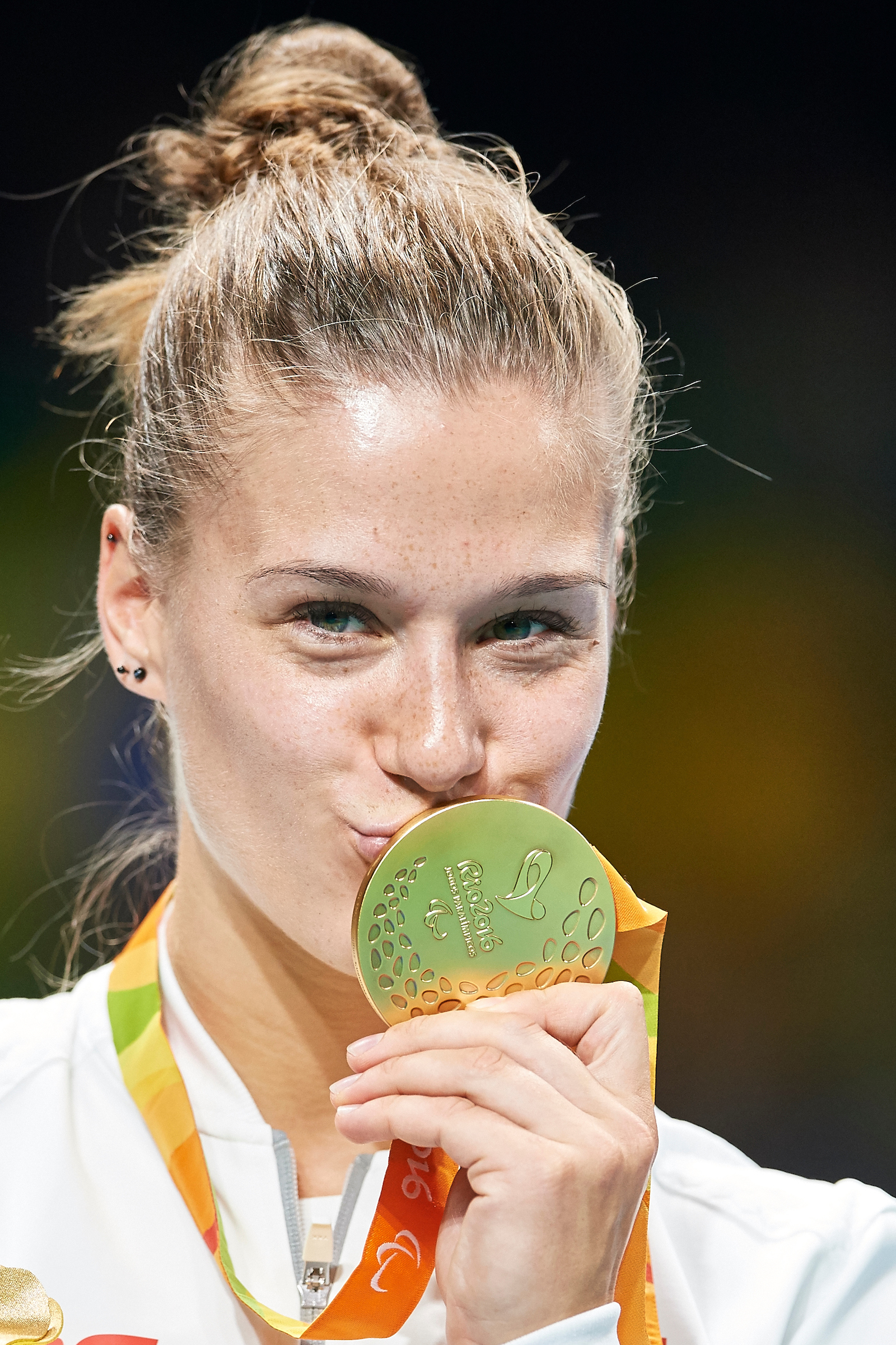 Na zdjęciu znajduje się kobieta (Natalia Partyka), która całuje złoty medal, wiszący na jej szyi. 