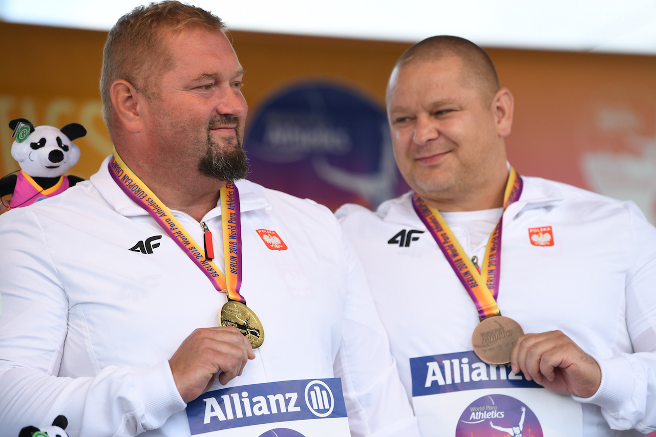 Na zdjęciu znajduje się dwóch uśmiechniętych mężczyzn z medalami na szyjach. Jeden z nich to Rokicki.