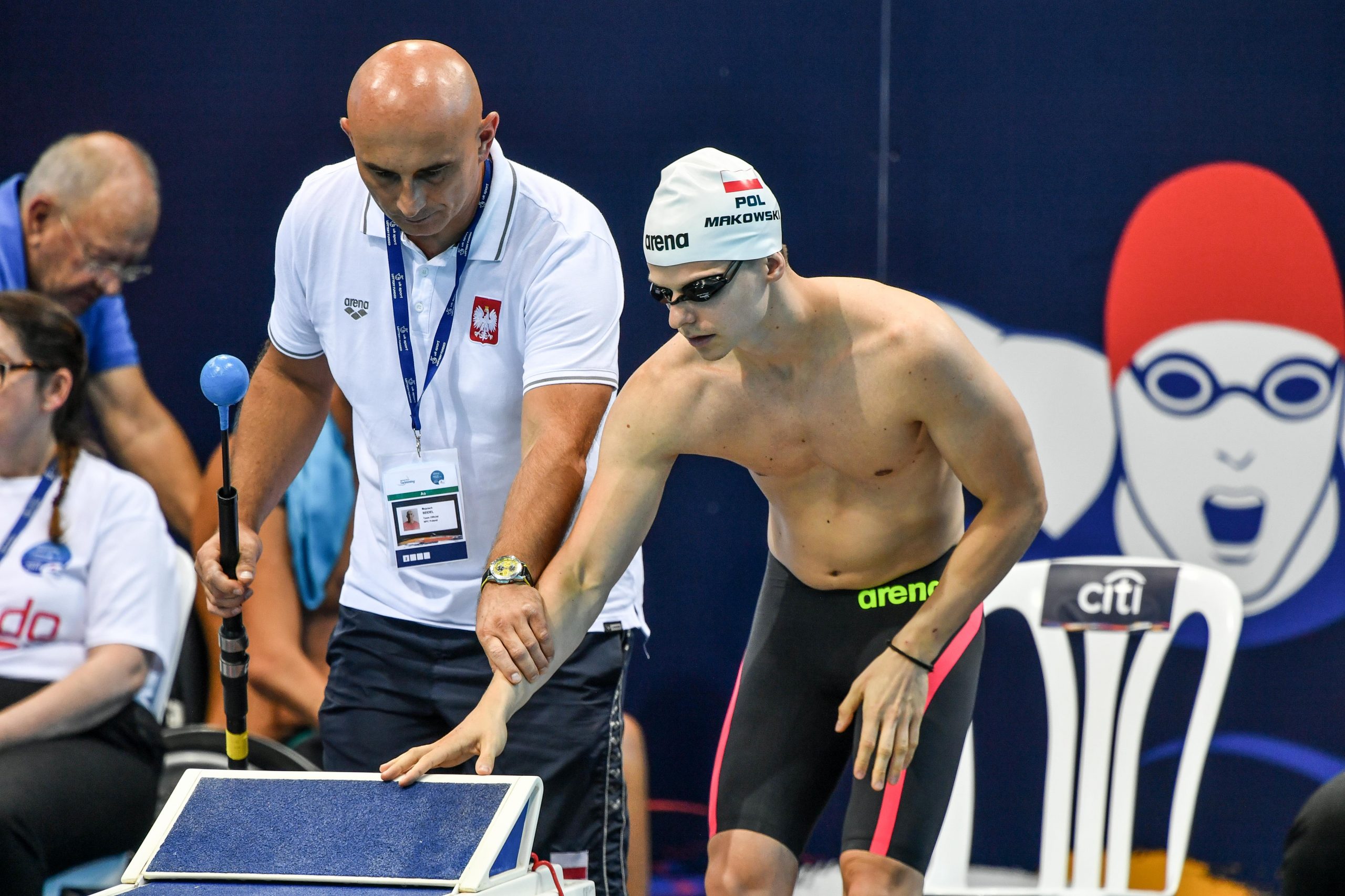 Na zdjęciu trener pomaga pływakowi (Makowski) wyczuć dłonią brzeg basenu.