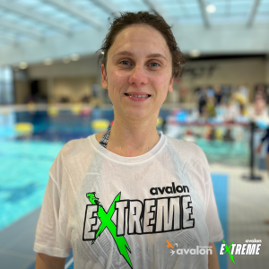 Uczestniczka nurkowania z projektem Avalon Extreme, po wyjściu z basenu. Ma na sobie mokrą koszulkę z logo projektu i jest uśmiechnięta.