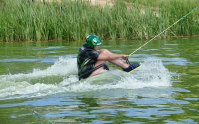 Mężczyzna w kasku z logiem Avalon Extreme płynie po jeziorze na sitwake.
